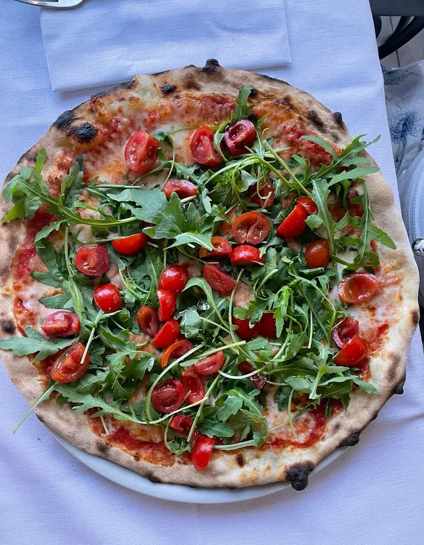 Pizza con rucola e pomodorini servita Da Loriano