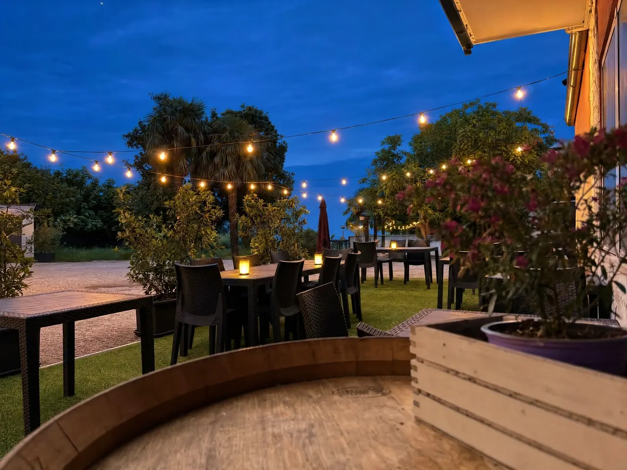 Il terrazzo serale della trattoria Da Loriano a Salcedo, con le lucine accese